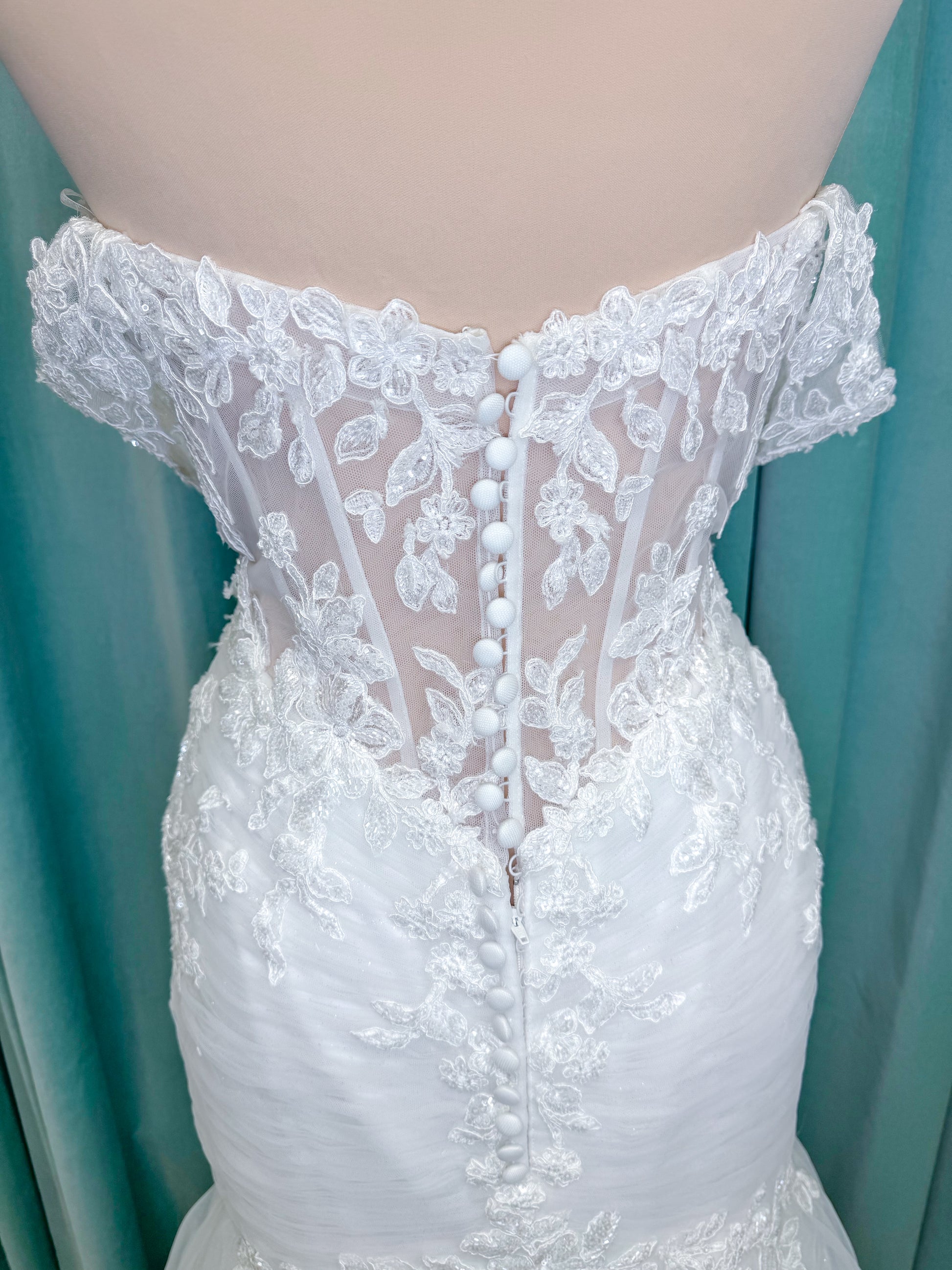 Morilee 4467 Rowena fit and flare wedding dress on mannequin with sheer corset bodice, frosted lace appliques, sweetheart neckline, and detachable off-the-shoulder sleeves