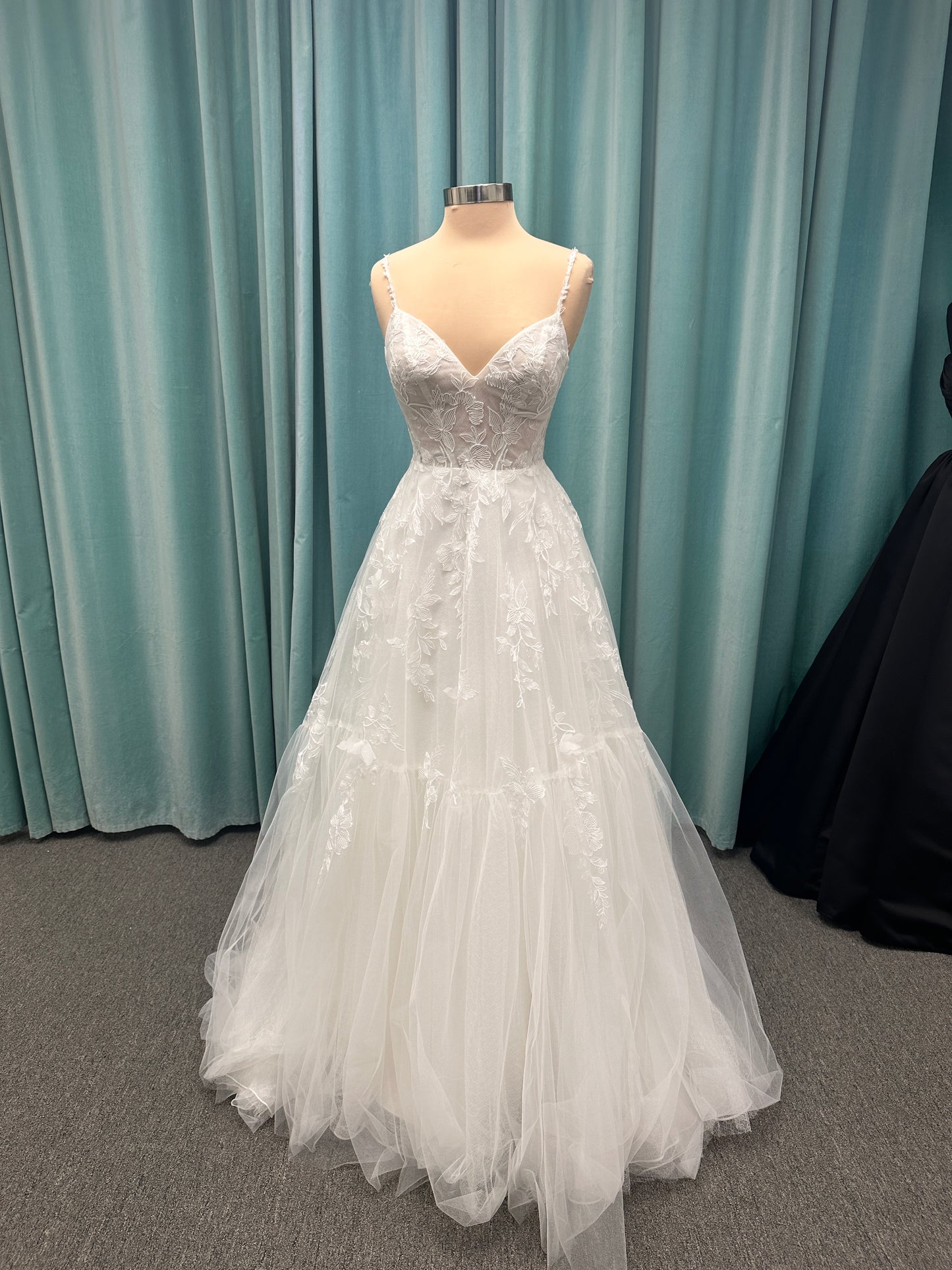 Stella York SY8153 ballgown featuring 3D lace spaghetti strap bodice with sheer V-neckline and layered tulle skirt with floral appliqués