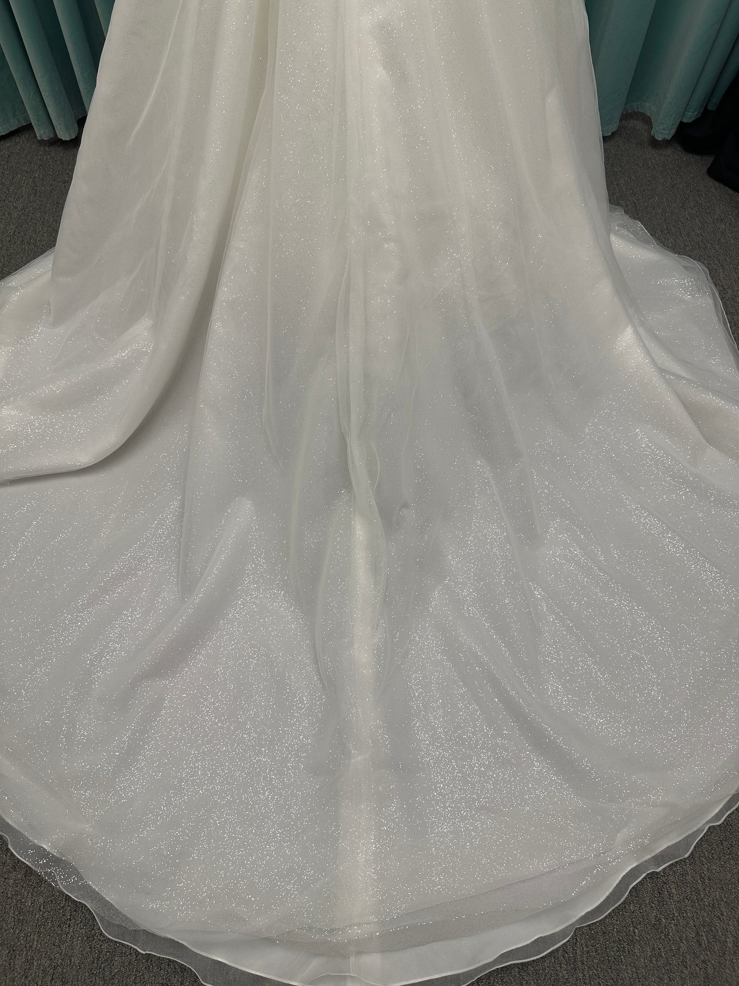 Strapless ballgown wedding dress with sheer boned bodice, sweetheart neckline, and lace appliqués flowing into a full tulle skirt