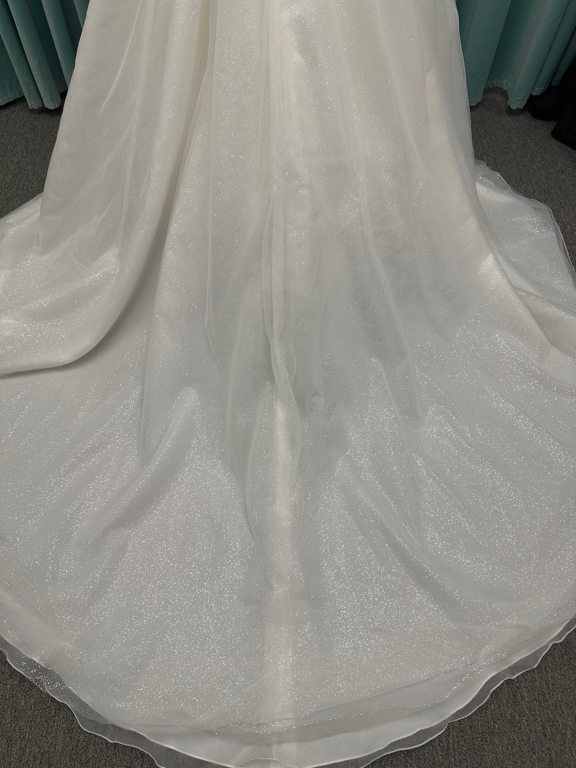 Strapless ballgown wedding dress with sheer boned bodice, sweetheart neckline, and lace appliqués flowing into a full tulle skirt