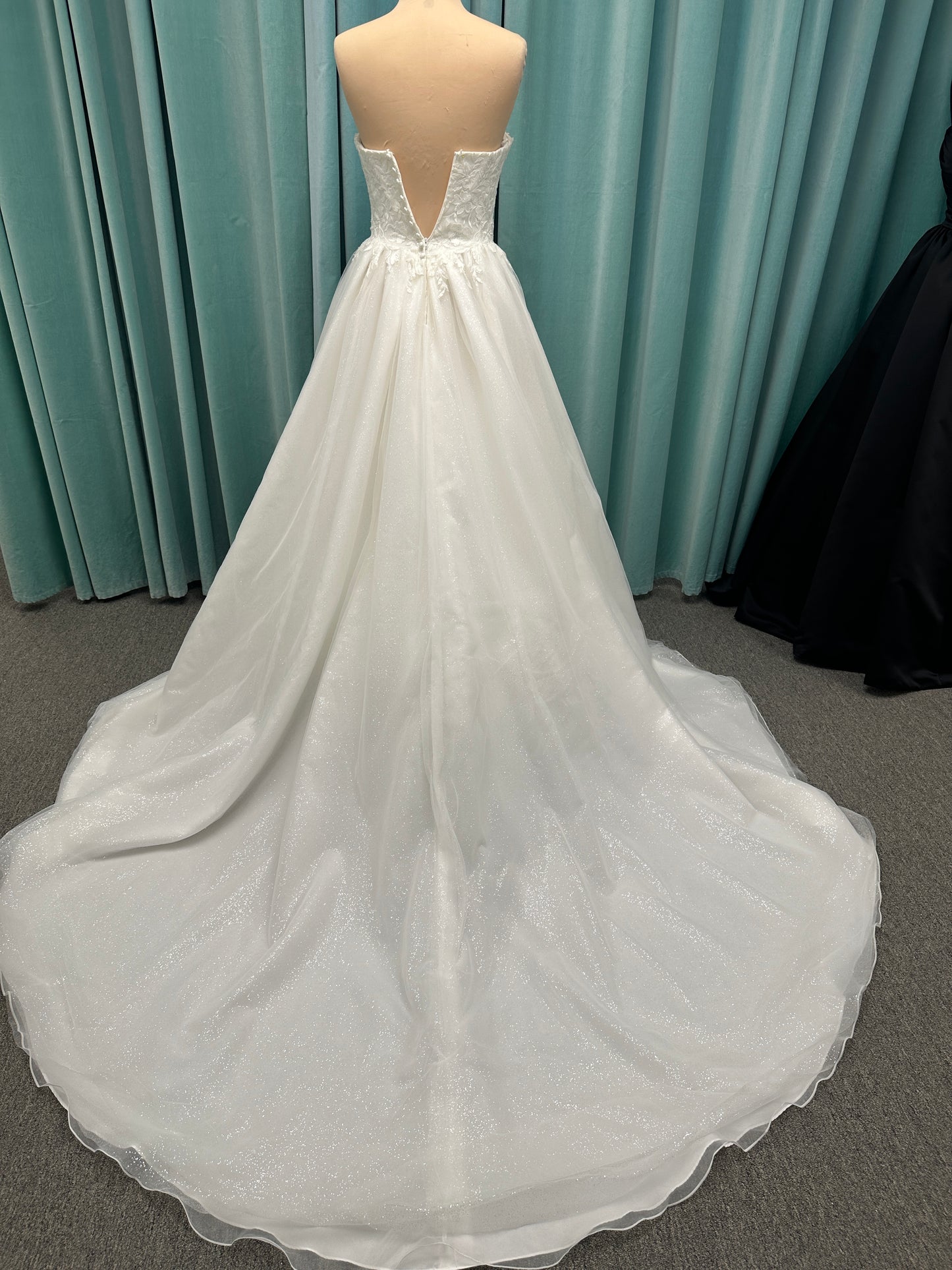 Strapless ballgown wedding dress with sheer boned bodice, sweetheart neckline, and lace appliqués flowing into a full tulle skirt