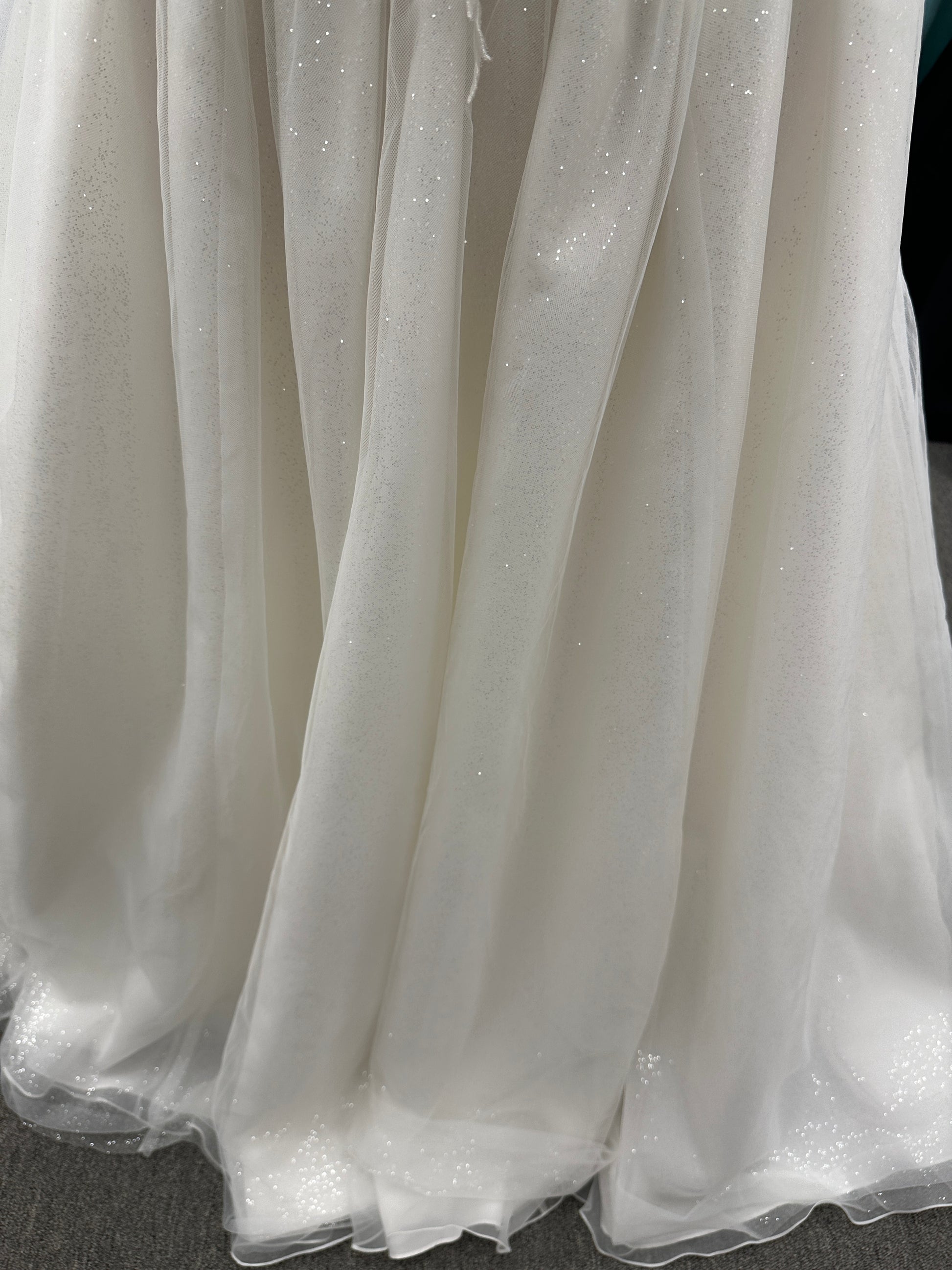 Strapless ballgown wedding dress with sheer boned bodice, sweetheart neckline, and lace appliqués flowing into a full tulle skirt