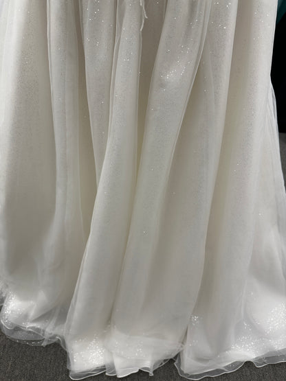 Strapless ballgown wedding dress with sheer boned bodice, sweetheart neckline, and lace appliqués flowing into a full tulle skirt