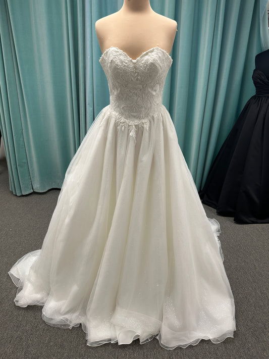 Strapless ballgown wedding dress with sheer boned bodice, sweetheart neckline, and lace appliqués flowing into a full tulle skirt