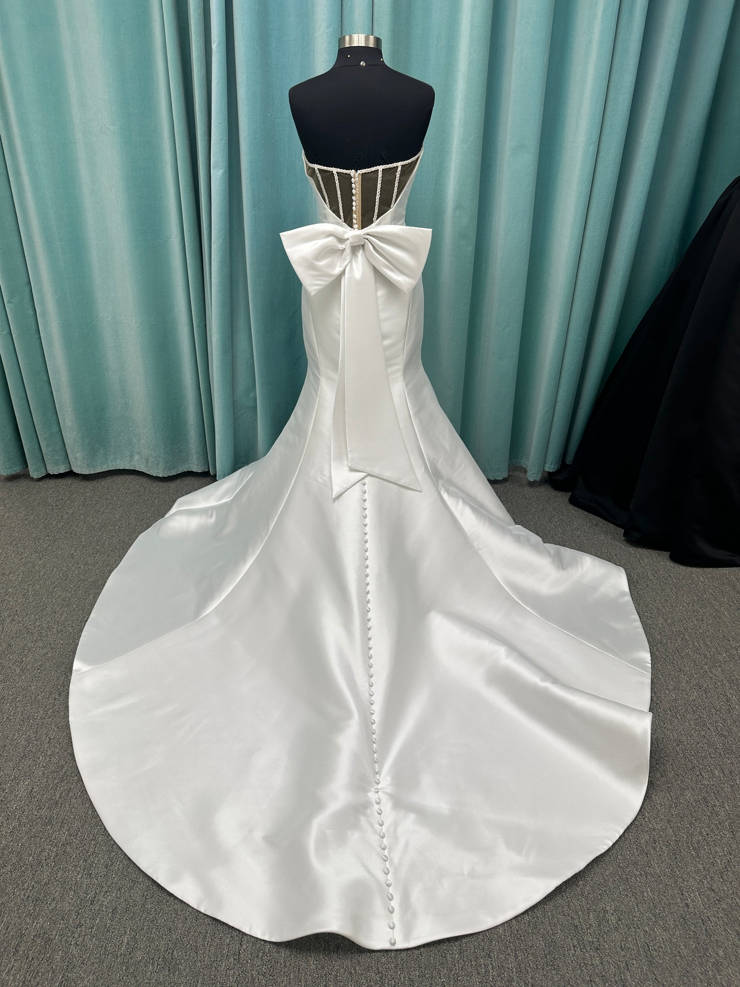 Strapless Mikado fit-and-flare wedding dress with sweetheart neckline, bow waist detail, and dramatic flared train by Stella York