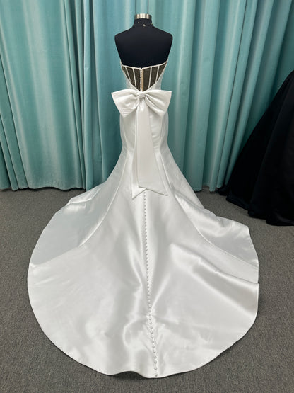 Strapless Mikado fit-and-flare wedding dress with sweetheart neckline, bow waist detail, and dramatic flared train by Stella York