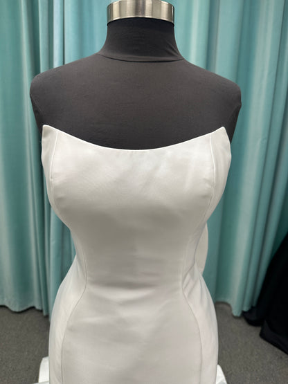 Strapless Mikado fit-and-flare wedding dress with sweetheart neckline, bow waist detail, and dramatic flared train by Stella York