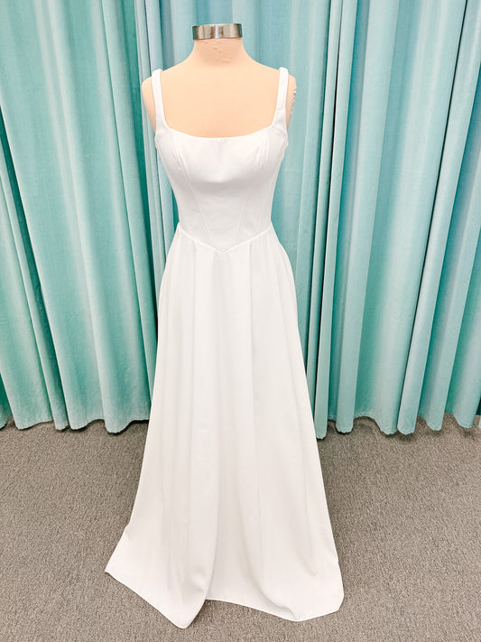 Stella York SY8180 A-line wedding dress on mannequin with wide straps, square neckline, contoured matte satin bodice, angled waist, and soft A-line skirt