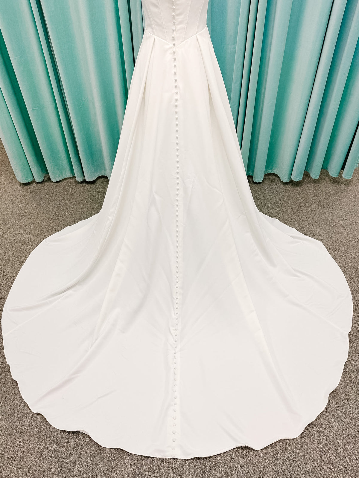 Stella York SY8180 A-line wedding dress on mannequin with wide straps, square neckline, contoured matte satin bodice, angled waist, and soft A-line skirt