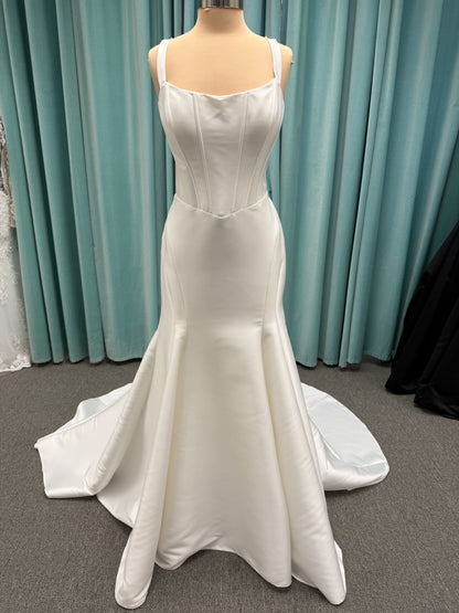 Stella York SY8148 ivory fit-and-flare wedding dress on mannequin featuring a modest scoop neckline, wide straps, and structured corset bodice.
