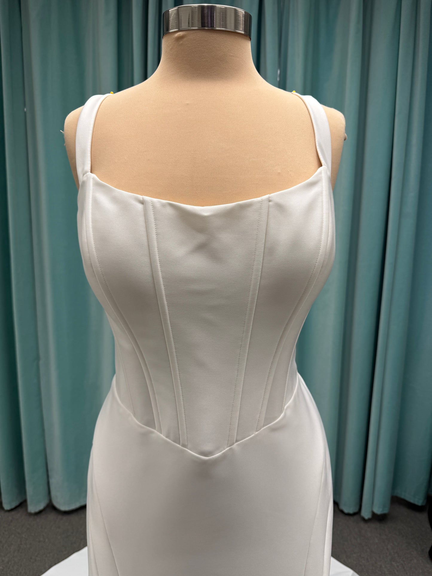 Stella York SY8148 ivory fit-and-flare wedding dress on mannequin featuring a modest scoop neckline, wide straps, and structured corset bodice.
