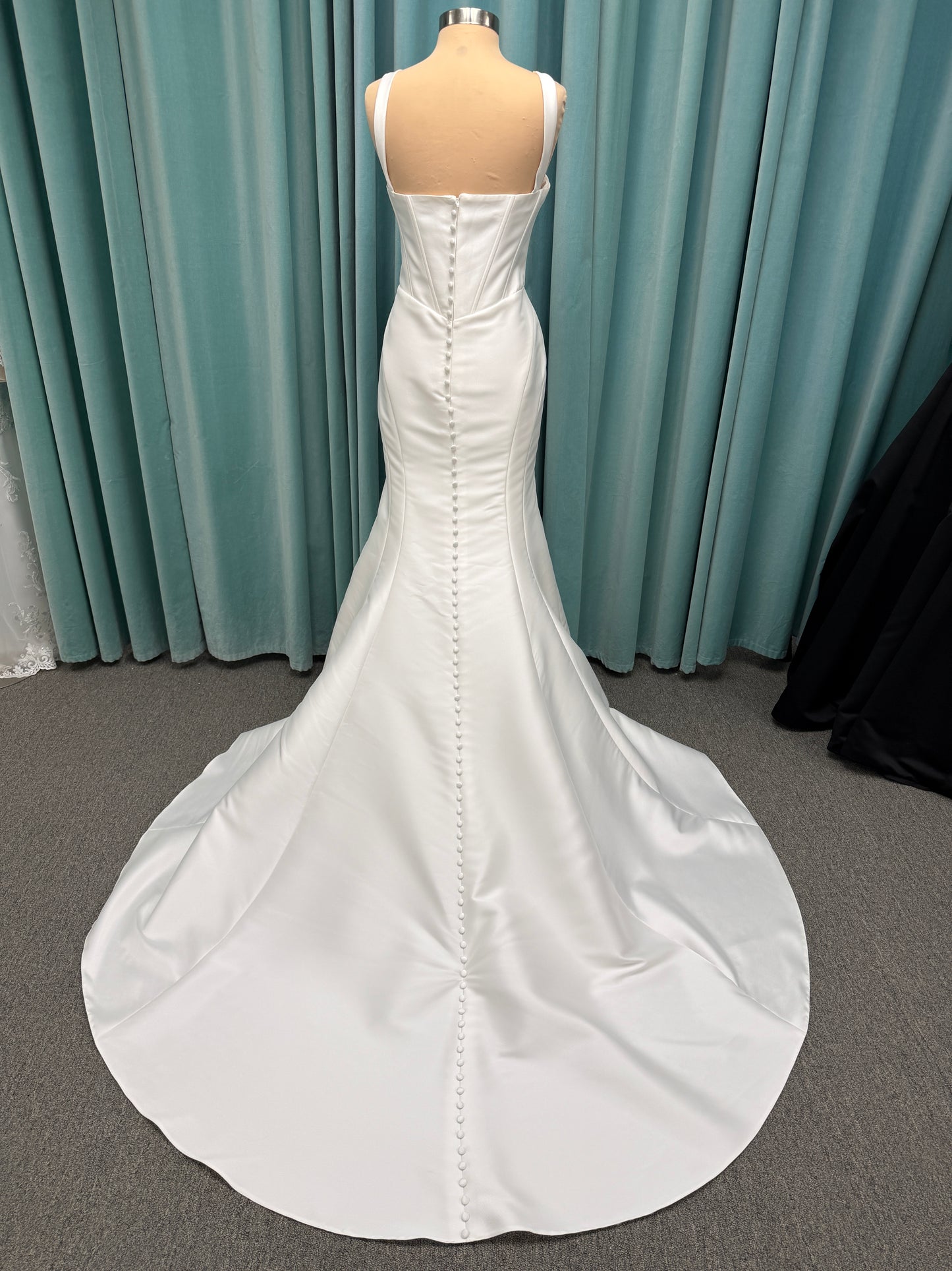 Stella York SY8148 ivory fit-and-flare wedding dress on mannequin featuring a modest scoop neckline, wide straps, and structured corset bodice.
