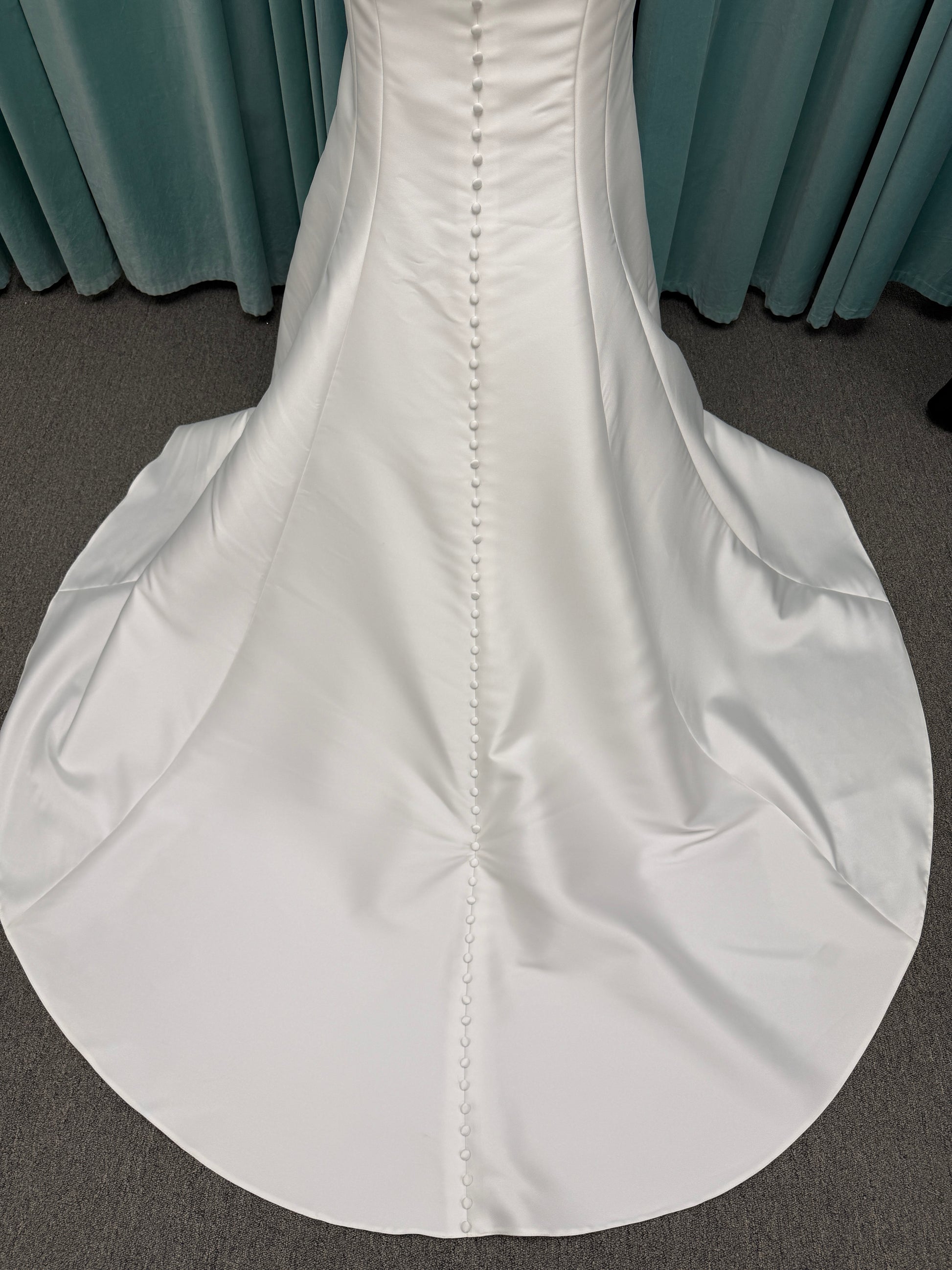 Stella York SY8148 ivory fit-and-flare wedding dress on mannequin featuring a modest scoop neckline, wide straps, and structured corset bodice.
