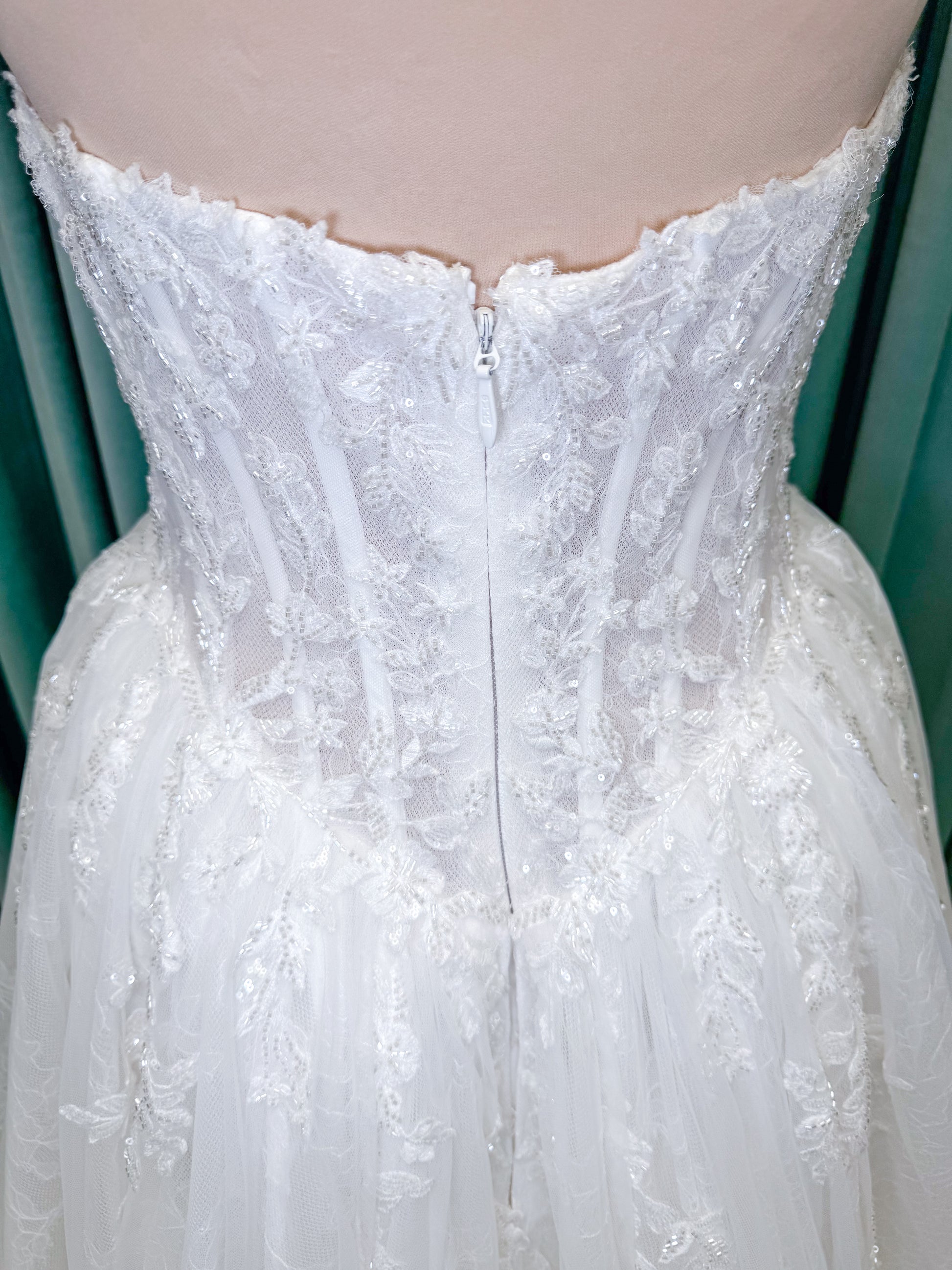 Morilee 2714 Seattle ballgown wedding dress on mannequin with crescent neckline, beaded embroidered lace, basque waist, and detachable illusion sleeves