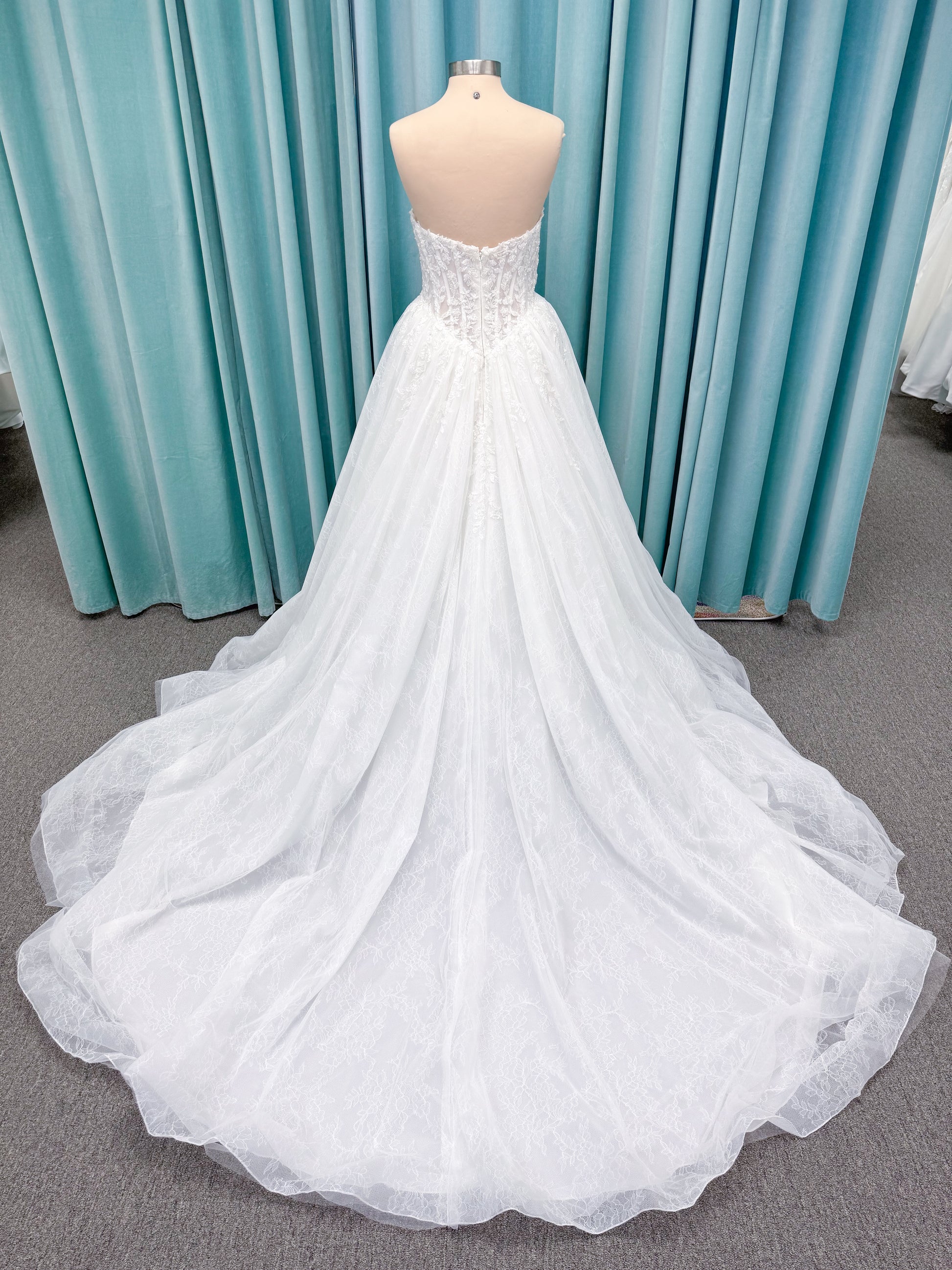 Morilee 2714 Seattle ballgown wedding dress on mannequin with crescent neckline, beaded embroidered lace, basque waist, and detachable illusion sleeves