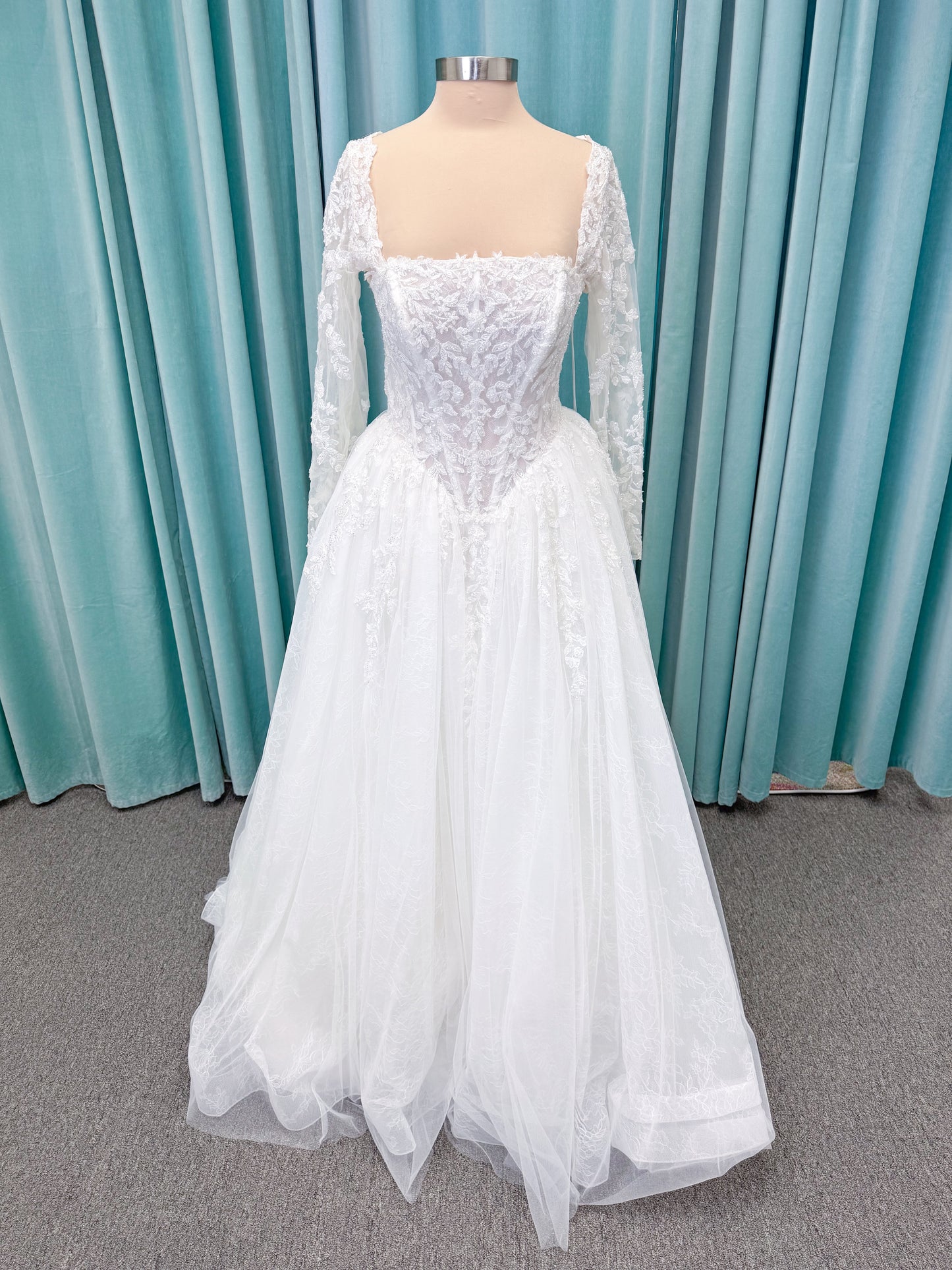 Morilee 2714 Seattle ballgown wedding dress on mannequin with crescent neckline, beaded embroidered lace, basque waist, and detachable illusion sleeves