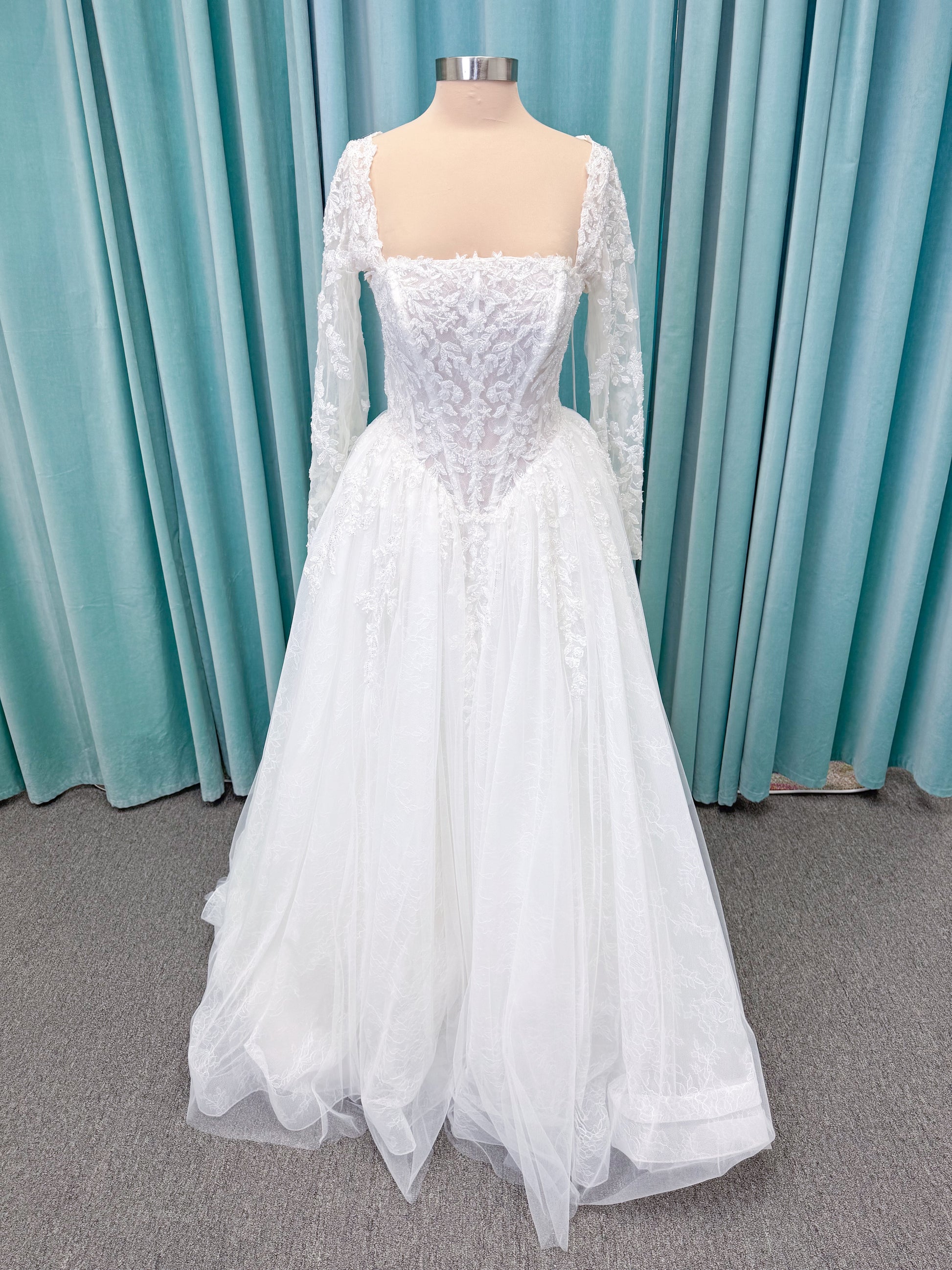 Morilee 2714 Seattle ballgown wedding dress on mannequin with crescent neckline, beaded embroidered lace, basque waist, and detachable illusion sleeves