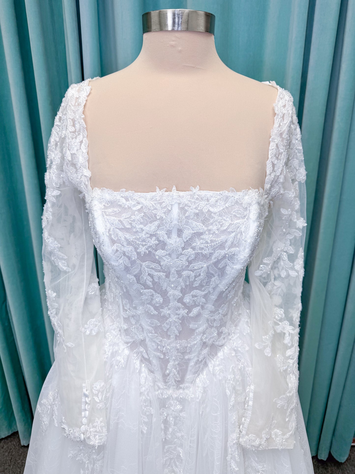 Morilee 2714 Seattle ballgown wedding dress on mannequin with crescent neckline, beaded embroidered lace, basque waist, and detachable illusion sleeves