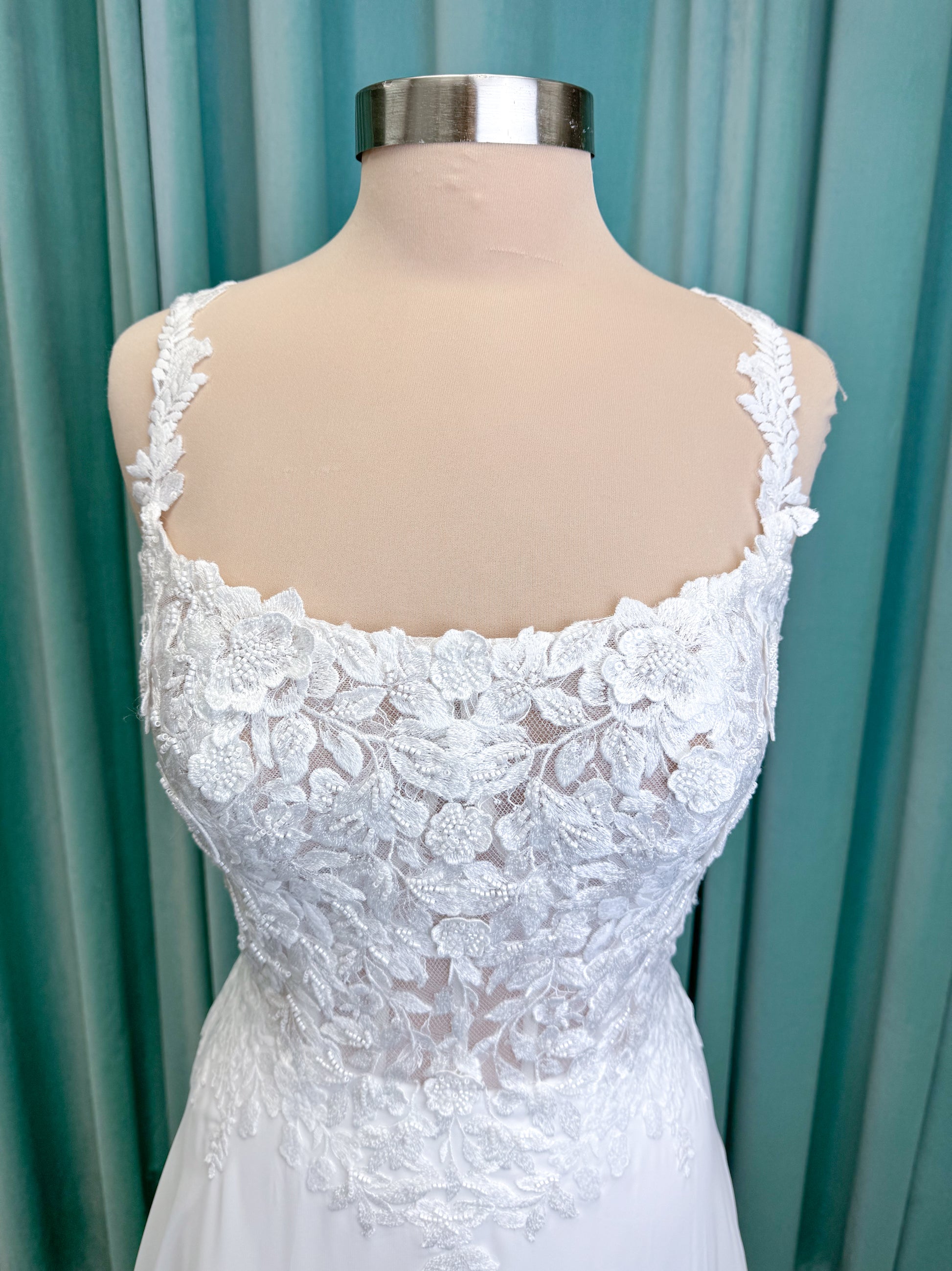Morilee 15108 Senna boho A-line wedding dress on mannequin with square neckline, 3D floral lace bodice, and flowing chiffon skirt