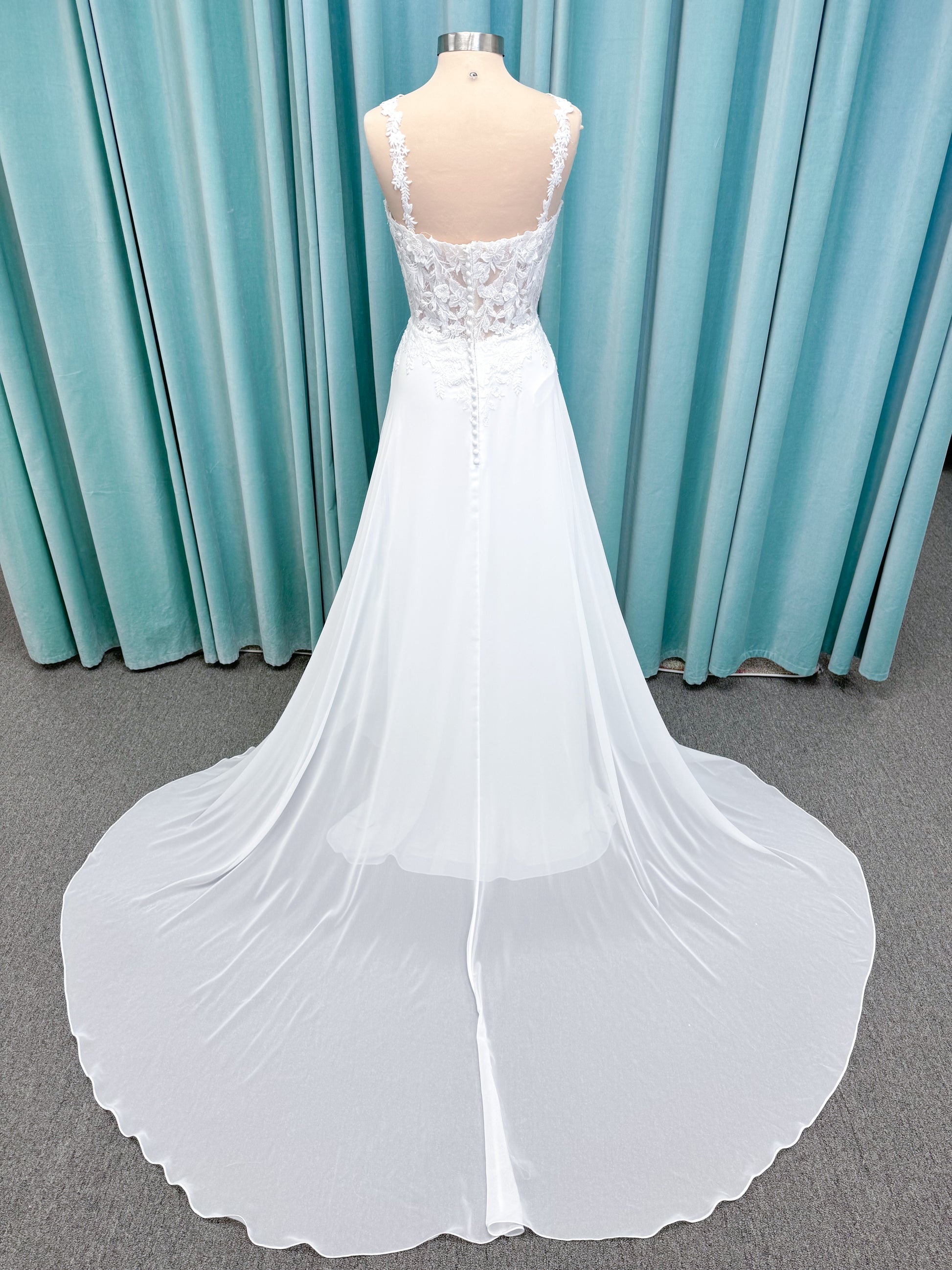 Morilee 15108 Senna boho A-line wedding dress on mannequin with square neckline, 3D floral lace bodice, and flowing chiffon skirt