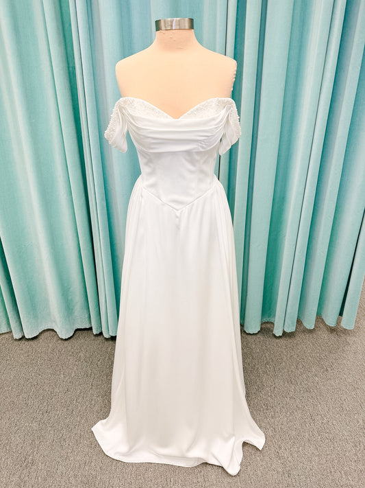 Stella York SY8236 A-line wedding dress on mannequin with pearl beaded sweetheart neckline, draped satin band, basque waist, and full satin skirt
