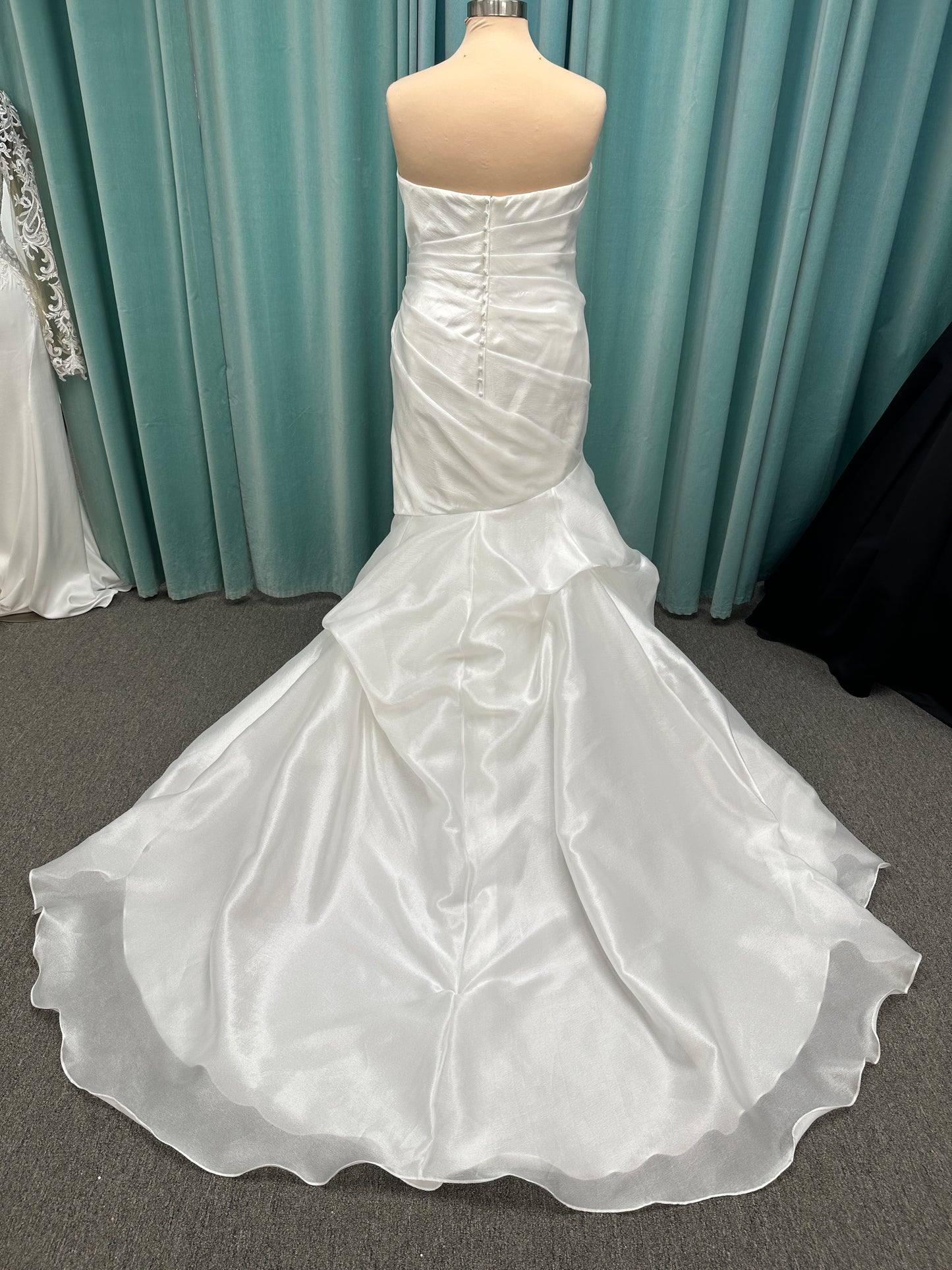 Ruched strapless fit-and-flare wedding dress with cat-eye neckline, asymmetrical skirt, and dramatic pickups by Stella York Style SY8123
