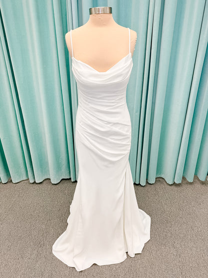 Stella York SY8224 sheath wedding dress on mannequin with spaghetti straps, draped scoop neckline, ruched crepe bodice, front slit, and detachable back cowl