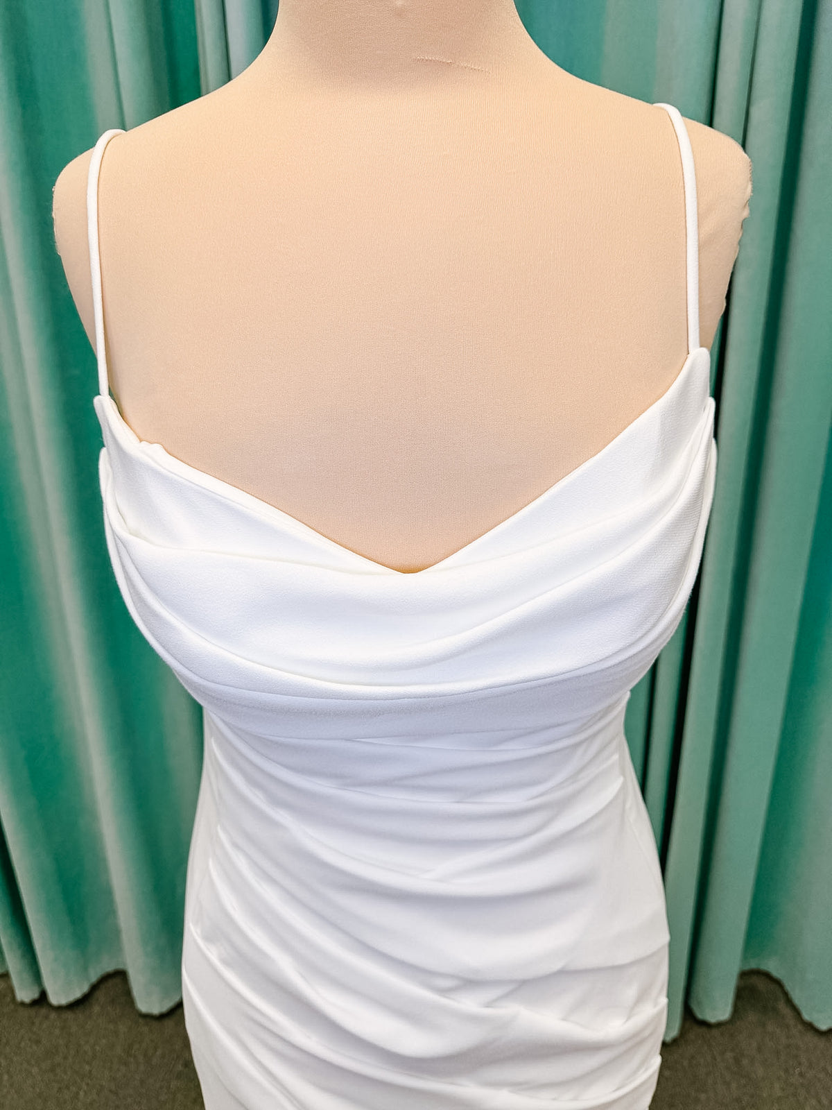 Stella York SY8224 sheath wedding dress on mannequin with spaghetti straps, draped scoop neckline, ruched crepe bodice, front slit, and detachable back cowl
