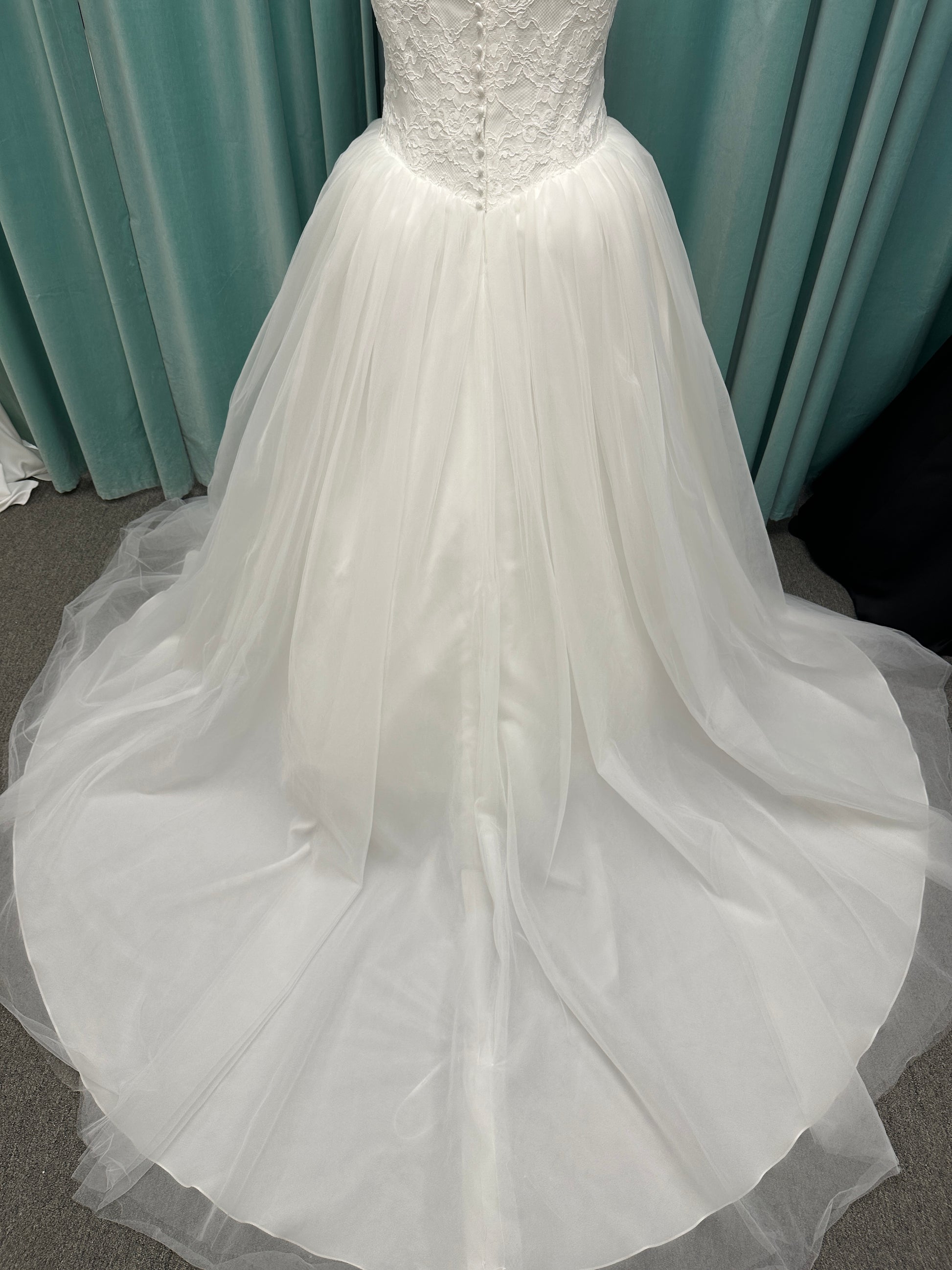 Plus size strapless lace ballgown wedding dress with cat-eye neckline, basque waist, full tulle skirt, and detachable satin bow by Stella York Style SY8189