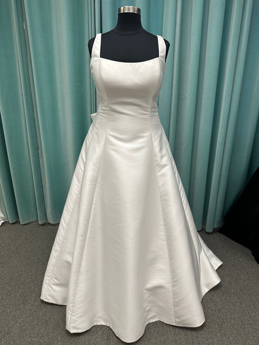 Minimalist Mikado A-line wedding dress with square neckline, clean seams, subtle side cutouts, and detachable oversized bow at the back