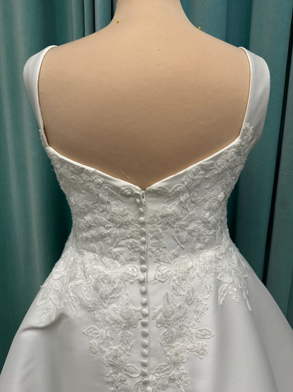 Plus size Stella York 7897 wedding dress in Mikado fabric with square neckline, lace bodice, side cutouts, and flowing A-line skirt with pockets