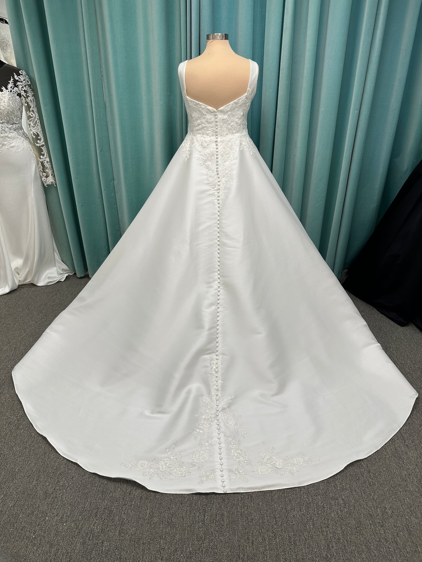 Plus size Stella York 7897 wedding dress in Mikado fabric with square neckline, lace bodice, side cutouts, and flowing A-line skirt with pockets