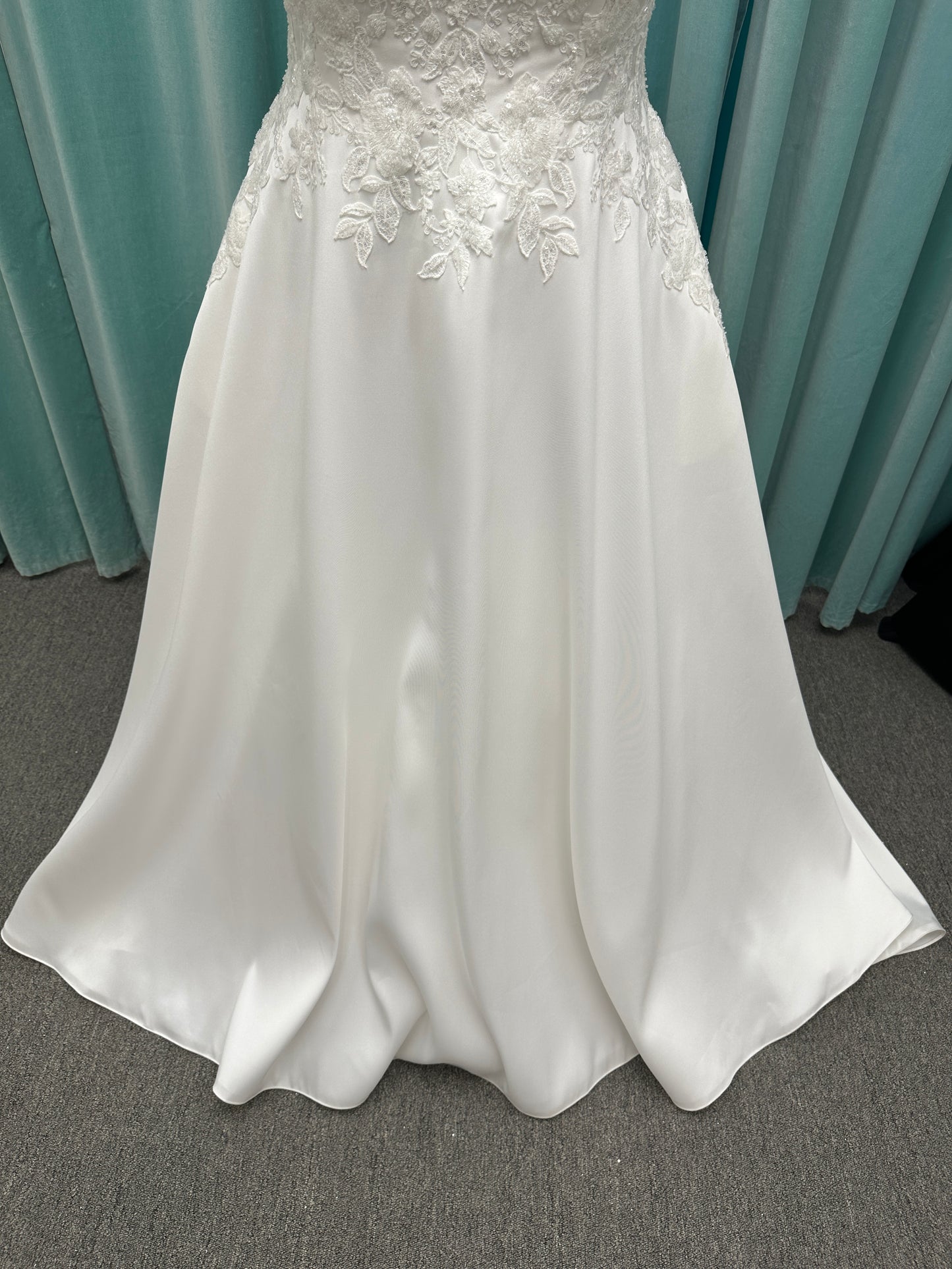Plus size Stella York 7897 wedding dress in Mikado fabric with square neckline, lace bodice, side cutouts, and flowing A-line skirt with pockets