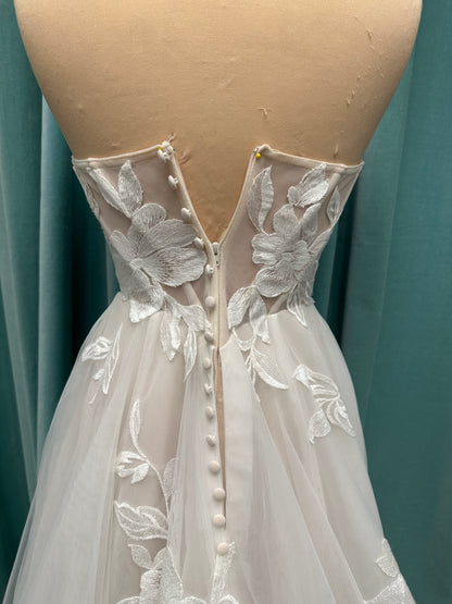 Strapless lace A-line wedding dress with sweetheart neckline, sheer corset bodice, and oversized floral lace appliqués by Stella York Style 7975
