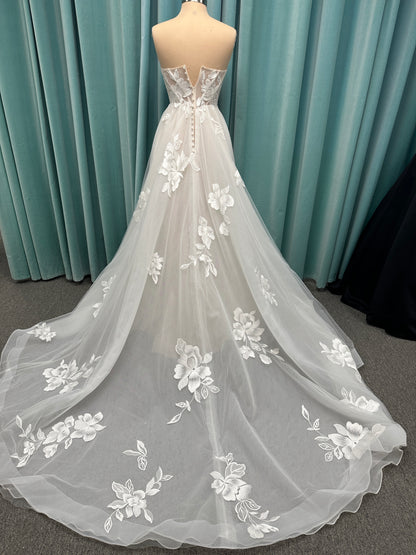 Strapless lace A-line wedding dress with sweetheart neckline, sheer corset bodice, and oversized floral lace appliqués by Stella York Style 7975