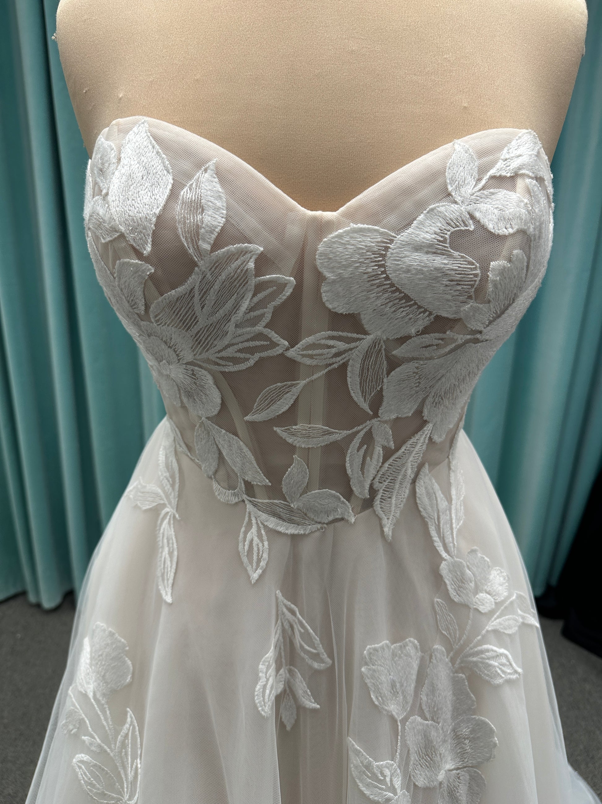 Strapless lace A-line wedding dress with sweetheart neckline, sheer corset bodice, and oversized floral lace appliqués by Stella York Style 7975