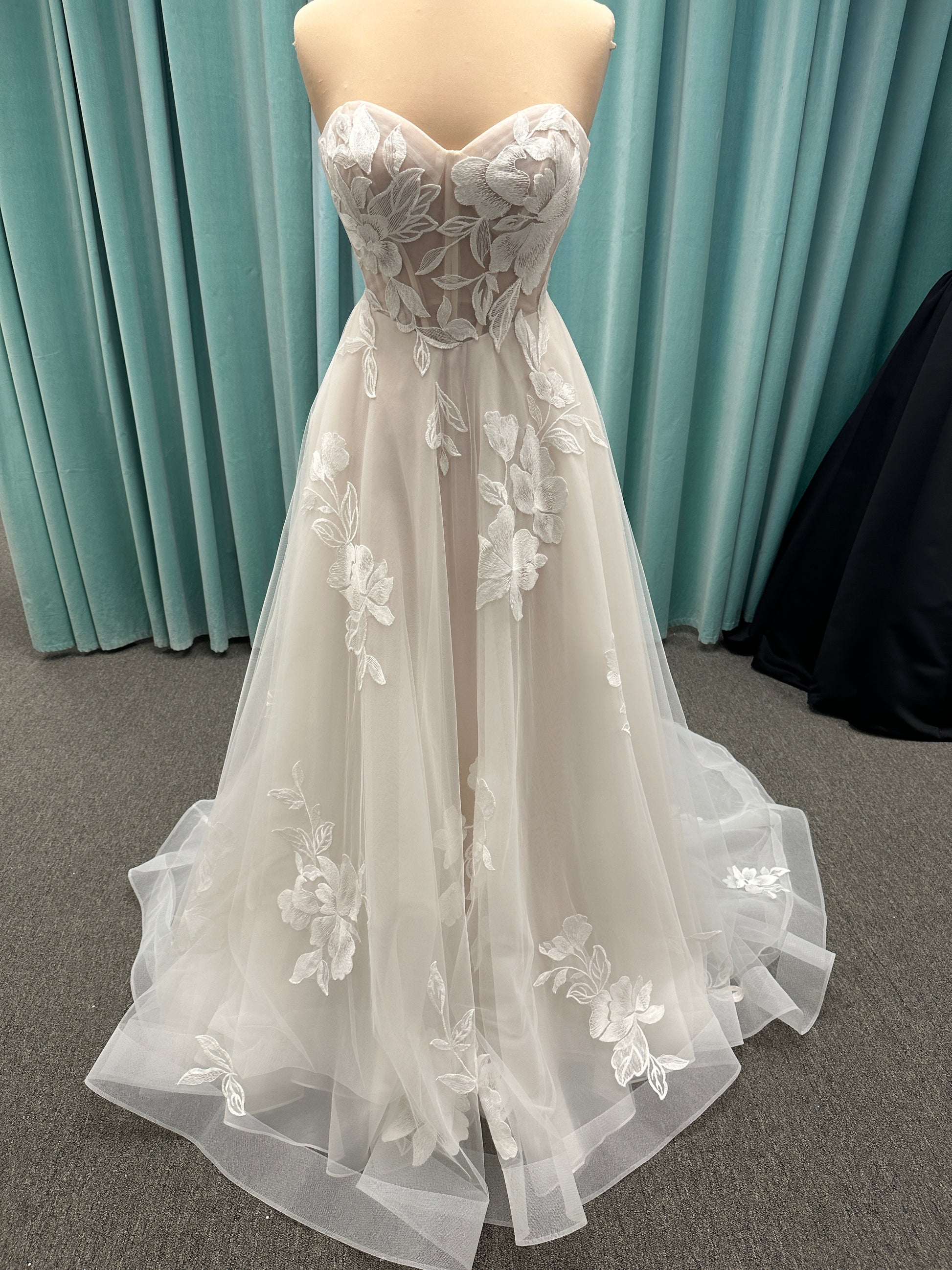 Strapless lace A-line wedding dress with sweetheart neckline, sheer corset bodice, and oversized floral lace appliqués by Stella York Style 7975