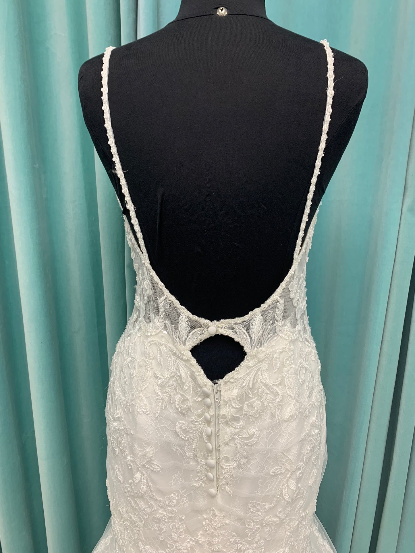 Starr ivory lace fit-and-flare wedding dress on mannequin with sweetheart neckline, delicate straps, and low open back with sweeping train.
