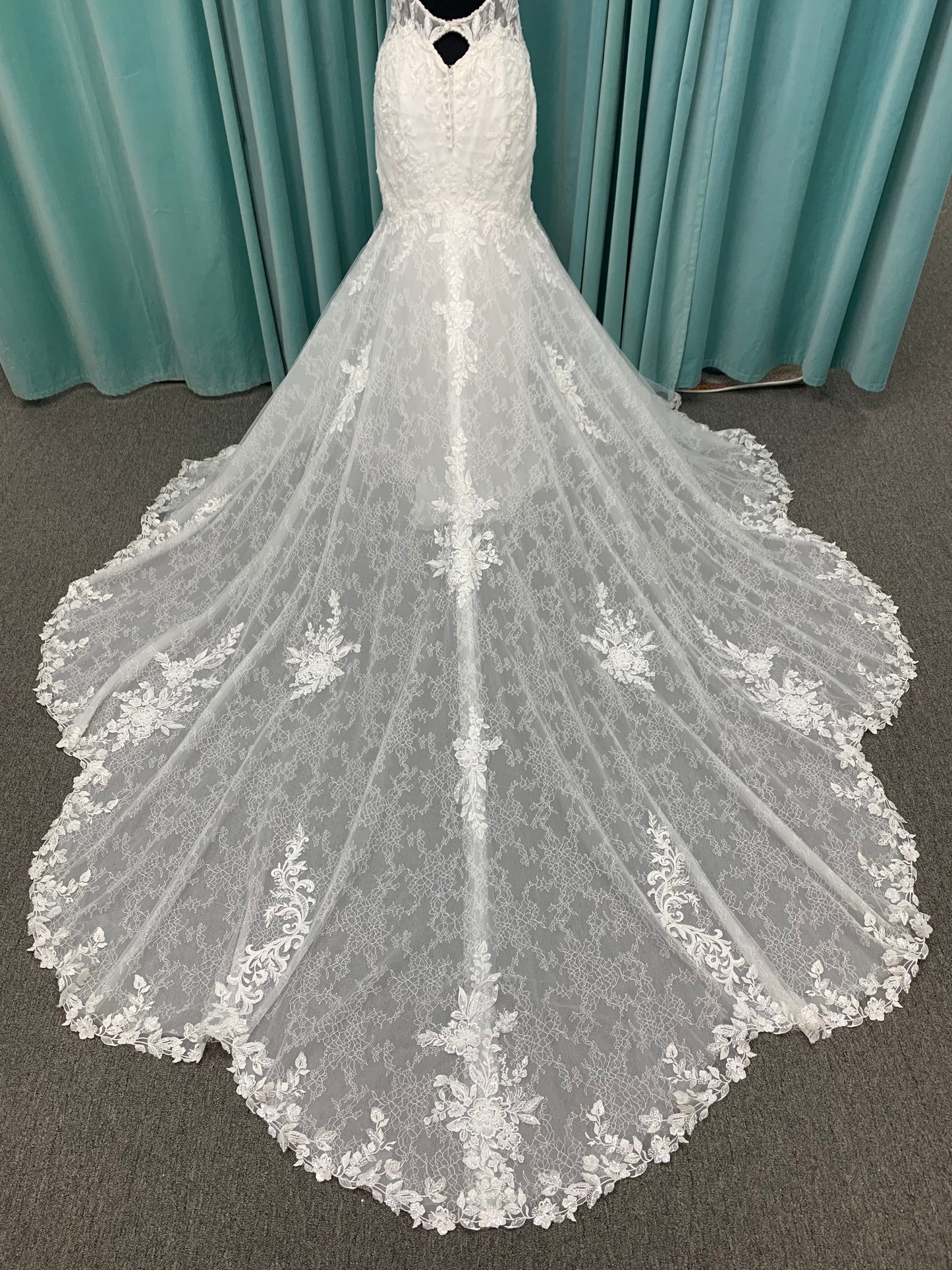 Starr ivory lace fit-and-flare wedding dress on mannequin with sweetheart neckline, delicate straps, and low open back with sweeping train.
