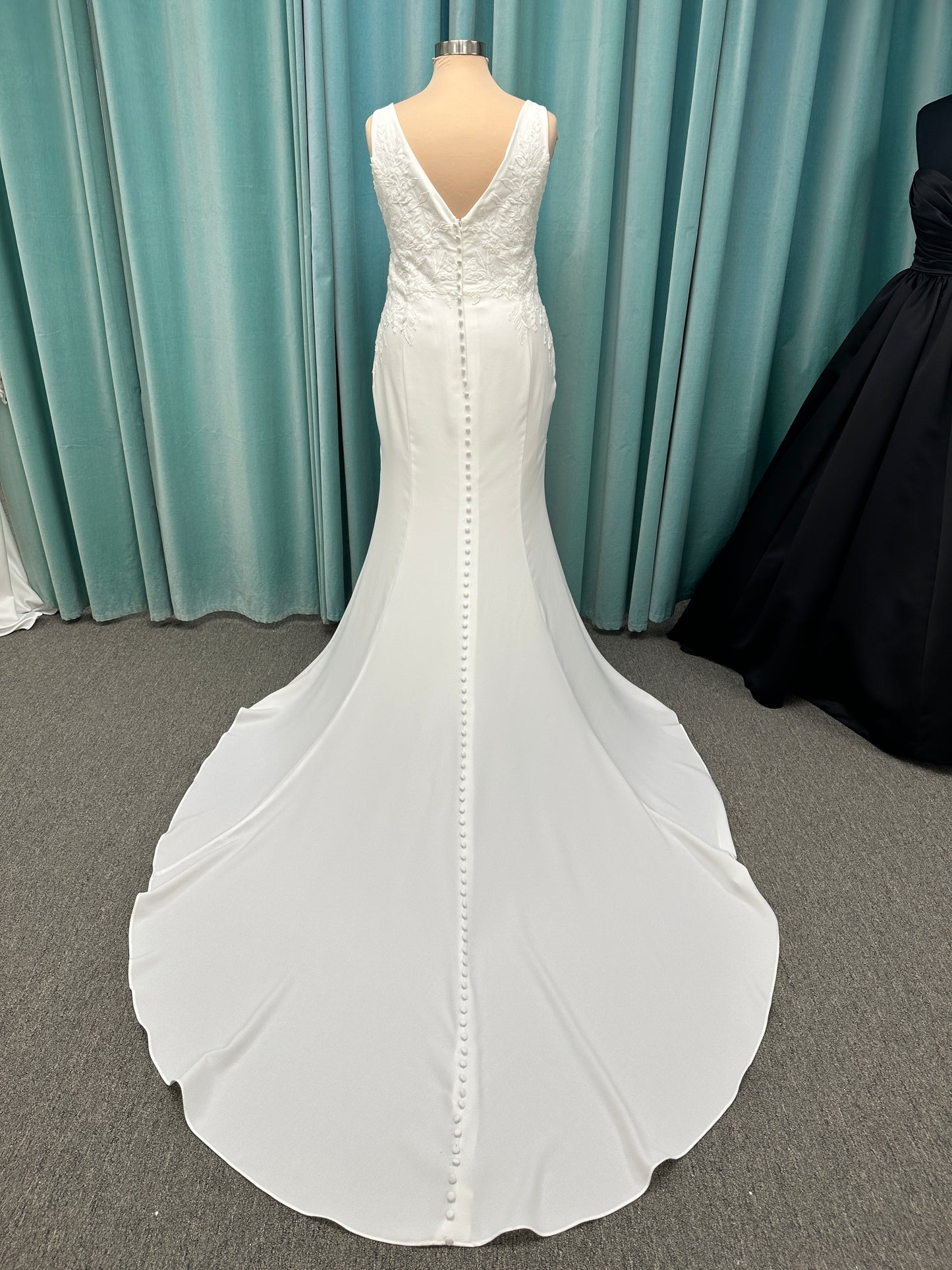 Stella York 7774 column sheath wedding dress with plunging neckline, lace appliqués, side cutouts, and crepe skirt with train
