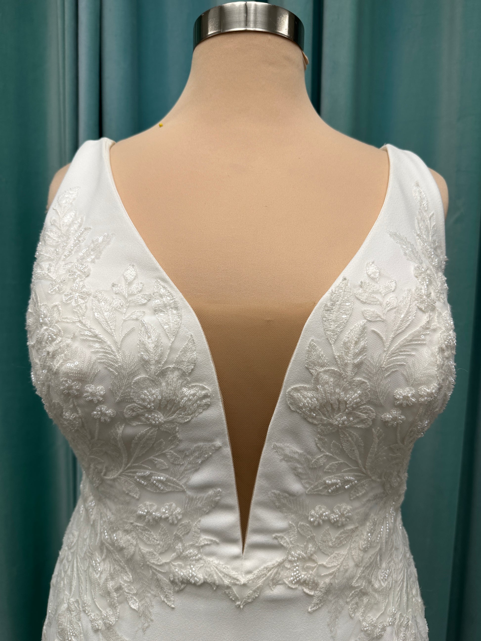 Stella York 7774 column sheath wedding dress with plunging neckline, lace appliqués, side cutouts, and crepe skirt with train
