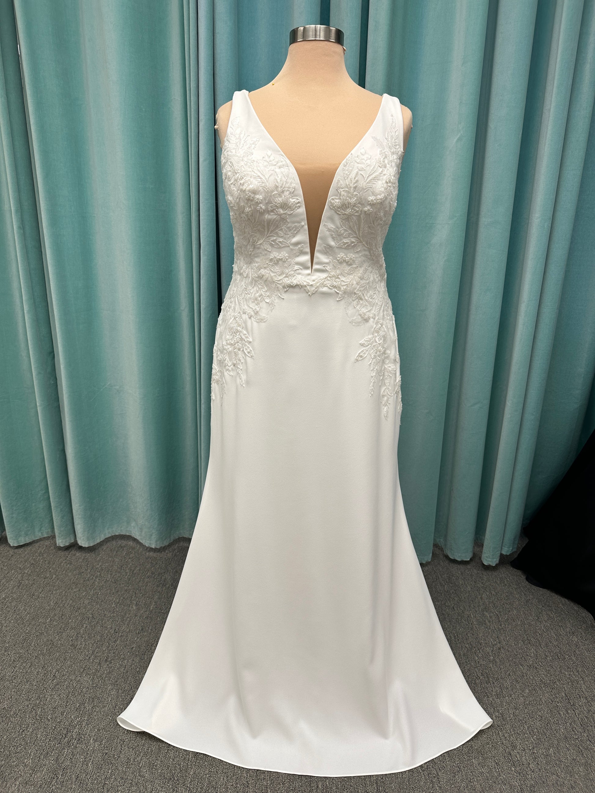 Stella York 7774 column sheath wedding dress with plunging neckline, lace appliqués, side cutouts, and crepe skirt with train