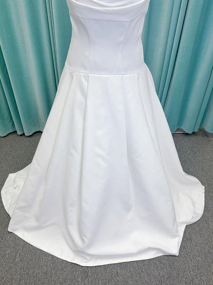 Morilee 15080 Tiana A-line wedding dress in satin with cowl-draped strapless neckline, drop waist, contoured seaming, pleated skirt, and covered buttons to hem.