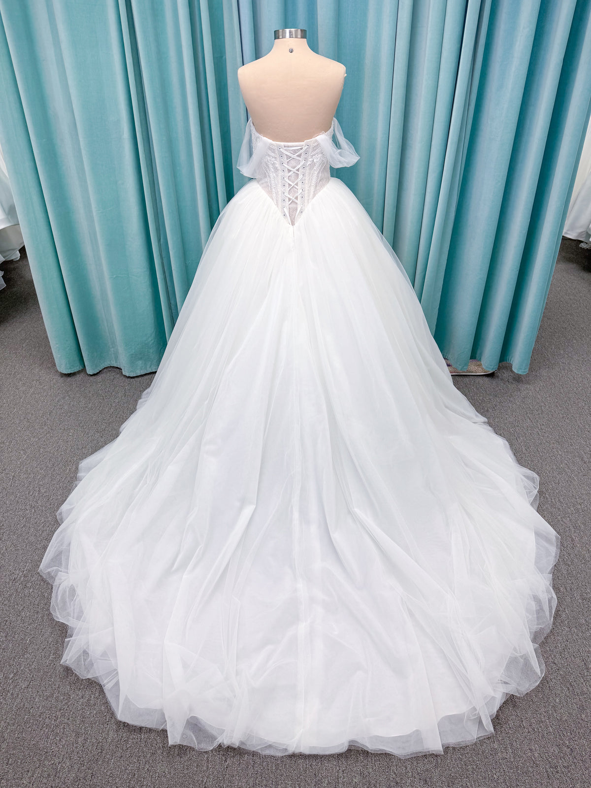 Morilee 1010036 Virtuoso ballgown wedding dress on mannequin with scoop neckline, off-the-shoulder tulle sleeves, beaded bodice, and lace-up corset back