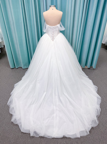 Morilee 1010036 Virtuoso ballgown wedding dress on mannequin with scoop neckline, off-the-shoulder tulle sleeves, beaded bodice, and lace-up corset back