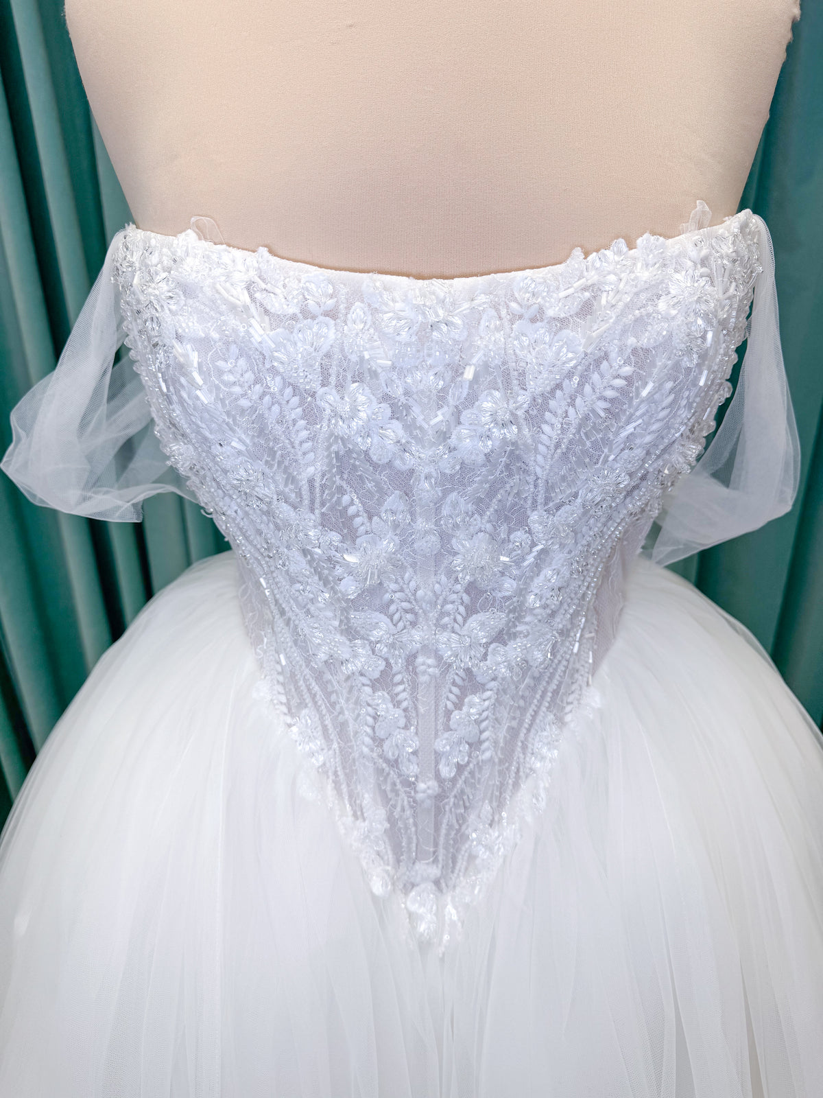 Morilee 1010036 Virtuoso ballgown wedding dress on mannequin with scoop neckline, off-the-shoulder tulle sleeves, beaded bodice, and lace-up corset back