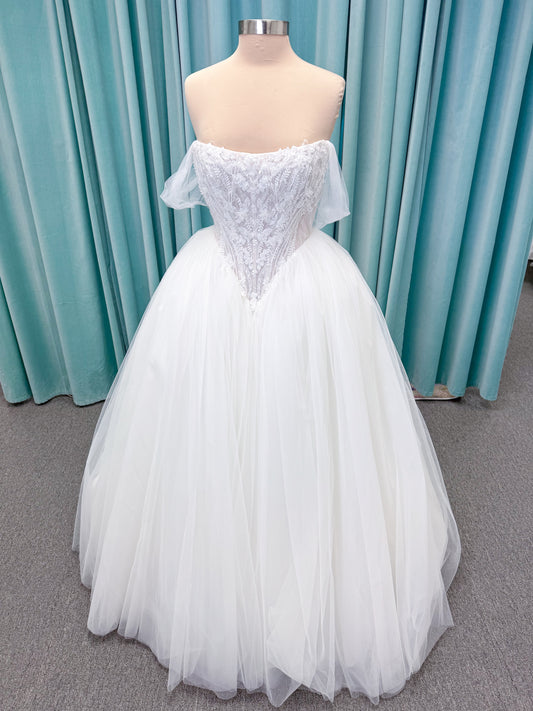 Morilee 1010036 Virtuoso ballgown wedding dress on mannequin with scoop neckline, off-the-shoulder tulle sleeves, beaded bodice, and lace-up corset back