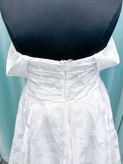 Willow ivory off-the-shoulder floral jacquard A-line wedding dress on mannequin with full skirt and front slit.
