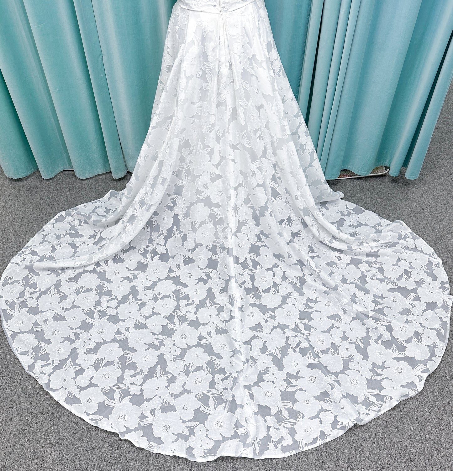 Willow ivory off-the-shoulder floral jacquard A-line wedding dress on mannequin with full skirt and front slit.
