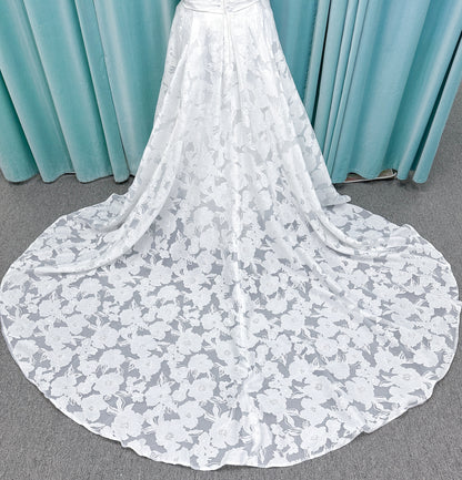 Willow ivory off-the-shoulder floral jacquard A-line wedding dress on mannequin with full skirt and front slit.
